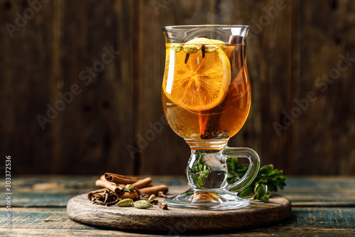 Grog. Hot drink for winter or autumn. Spicy tea and rum cocktail with lemon, cardamom, cinnamon and cloves. photo