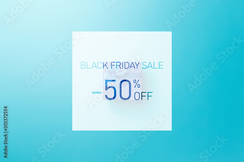 Black friday sale. Up to 50% discount. Text over Blue gift box with blue ribbon on blue background. Word BLACK FRIDAY on blue background. Flat lay. Minimal creative concept. Trendy pastel color