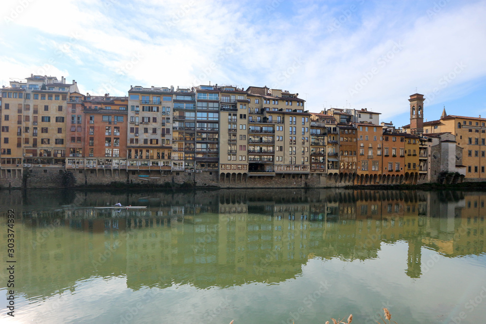 Winter view of the Arno River and medieval houses with their reflections in the water, Florence, Italy
