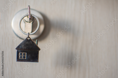 close up key on the door with morning light, personal loan concept. subject is blurry. © suparat1983