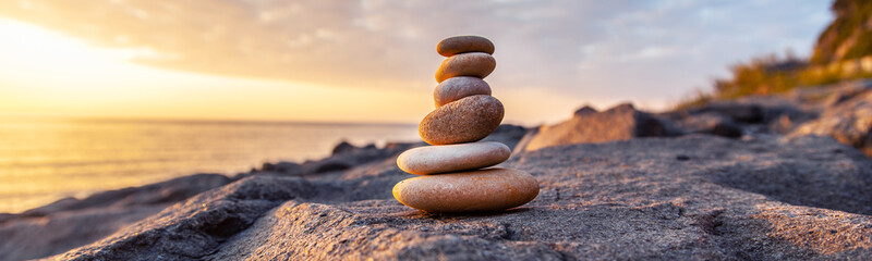 Stones pyramid on the seashore at sunset