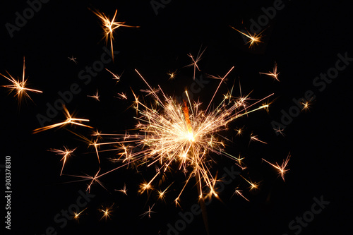 Fire spark xmas with black background. Magic glowing flow of sparks in the dark. Sparkler