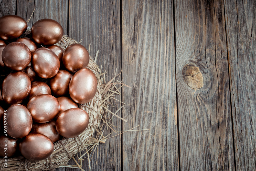 Obraz premium Background with Golden Easter eggs on wooden background.