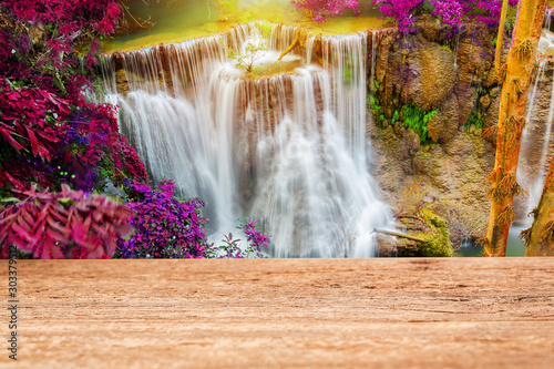 Wood table top on beautiful waterfall background © pushish images