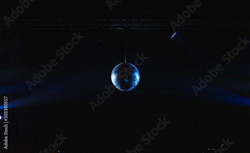 Mirror disco ball under the ceiling in a nightclub.