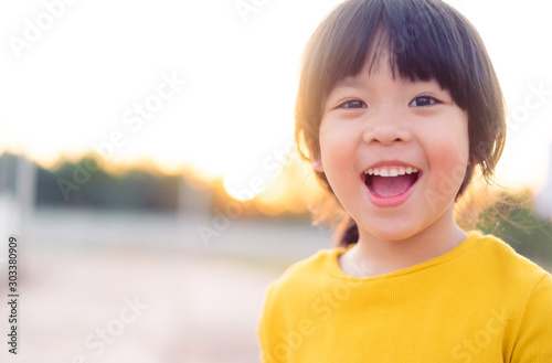 Happy Little asian girl child showing front teeth with big smile and laughing: Healthy happy funny smiling face young adorable lovely female kid.Joyful portrait of asian elementary school student.