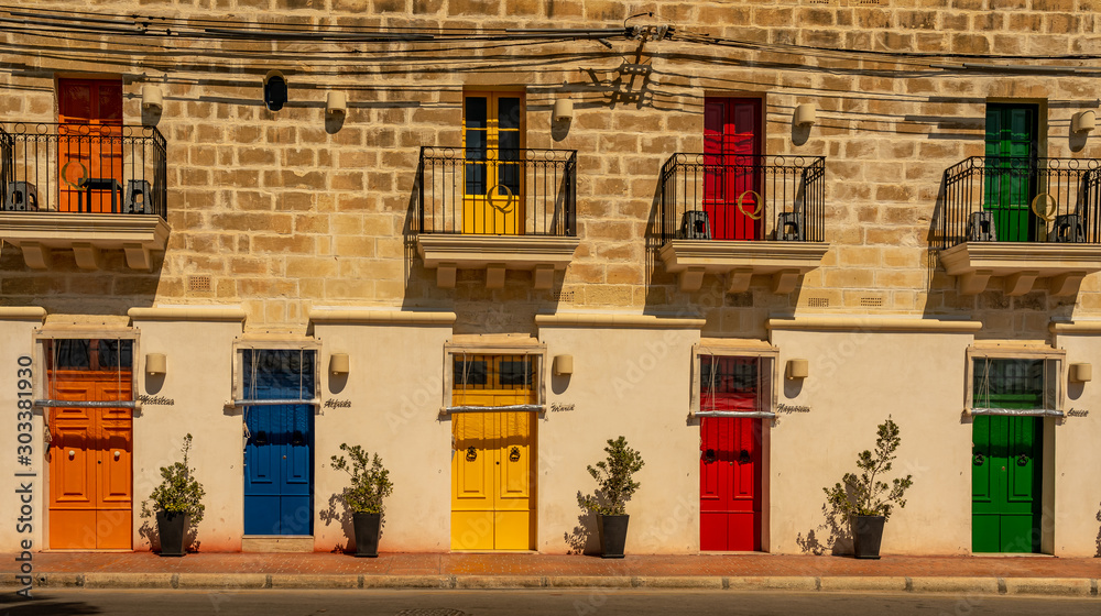 Φωτογραφία colorful doors of a building at the harbor of marsaxlokk on malta