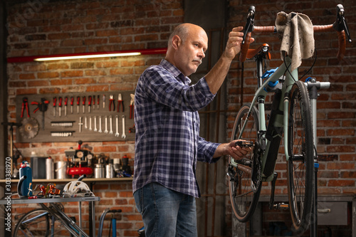 Mechanic in a workshop testing gear shift level on a bicycle