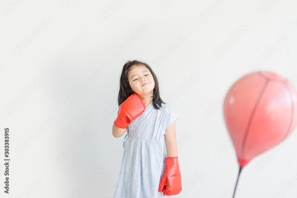 Little asian girl assuming stance, practicing self-defense and boxing.5 years old little asian japanese girl wearing a pair of boxing gloves and practice boxing. Little asian girl assuming stance, practicing self-defense and boxing.5 years old little asian japanese girl wearing a pair of boxing gloves and practice boxing.