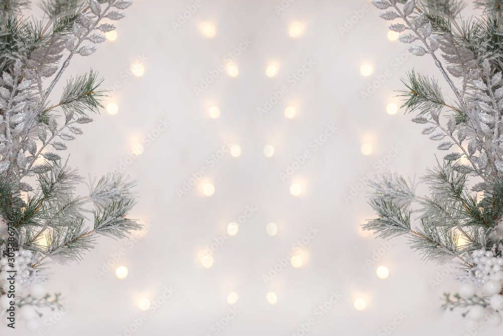 New Year's silver shiny ball hanging on a fir branch. Lights and garlands on a gray snow background. Christmas and happy new year concept, space for text for your design. Wallpaper. New Year's silver shiny ball hanging on a fir branch. Lights and garlands on a gray snow background. Christmas and happy new year concept, space for text for your design. Wallpaper.