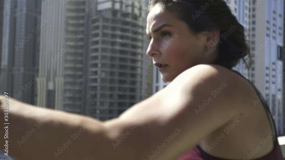Young sports gir fast boxing punches on the roof of a building with a city view. Hands in boxing bandages. Close-up. Slow motion. Young sports gir fast boxing punches on the roof of a building with a city view. Hands in boxing bandages. Close-up. Slow motion.