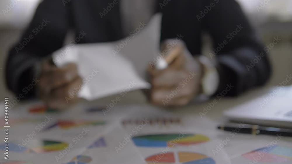 Defocused black manager tearing up financial documents.Frustration, stress Defocused black manager tearing up financial documents.Frustration, stress