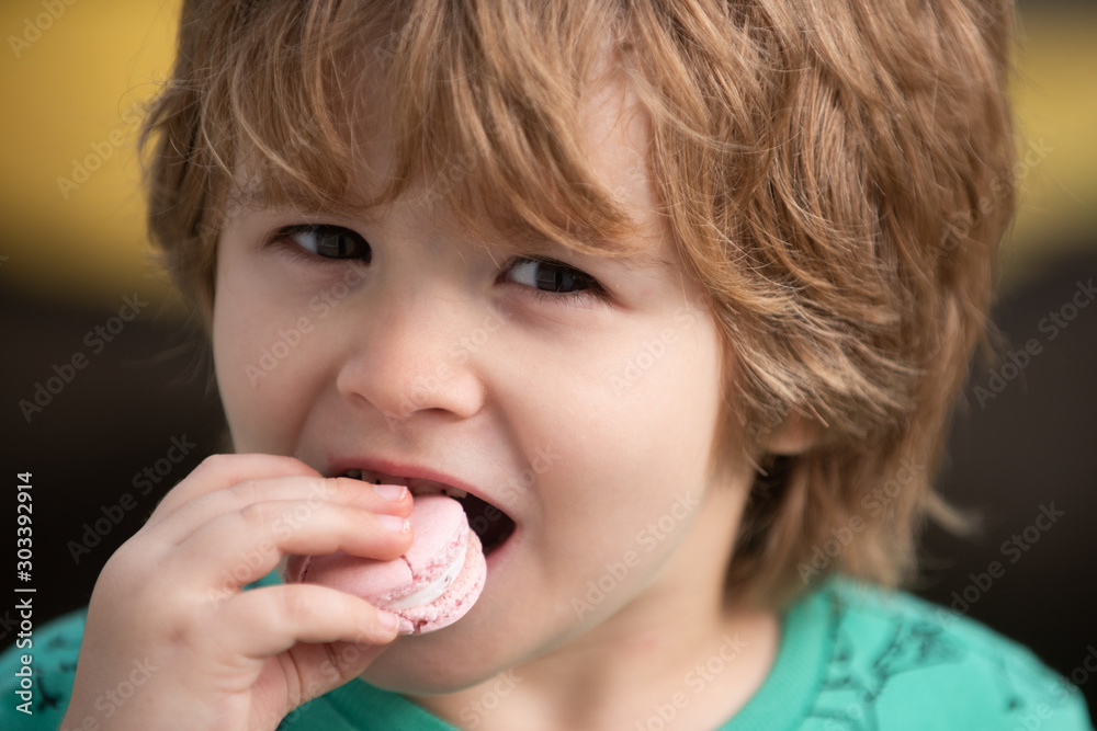 Cute child eats macaroon. Portrait with sweets. Calories and dessert. Tasty biscuit cookie. Young kid having a snack breaks with delicacy macaroon. Pastry pink macaroon. Cute child eats macaroon. Portrait with sweets. Calories and dessert. Tasty biscuit cookie. Young kid having a snack breaks with delicacy macaroon. Pastry pink macaroon.