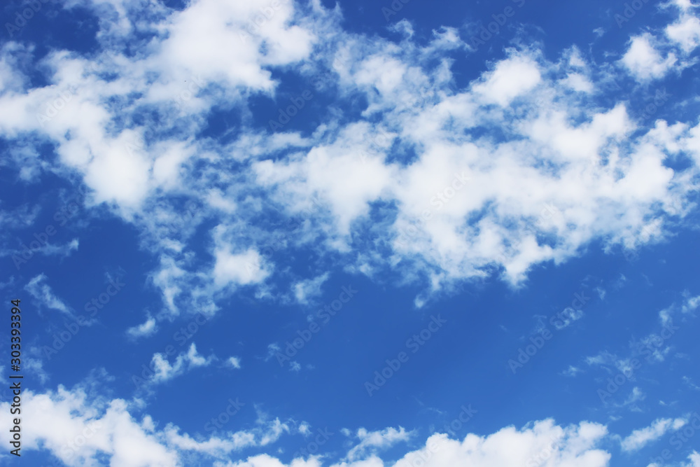 Blue sky with floating white clouds.