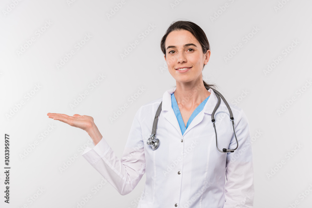 Pretty young smiling clinician in whitecoat presenting new medical product Pretty young smiling clinician in whitecoat presenting new medical product