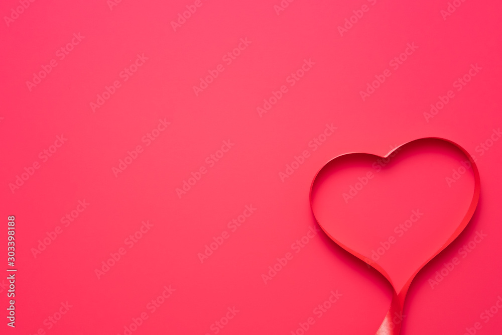 Top view of ribbon shaped as heart on red background. Valentine's Day concept