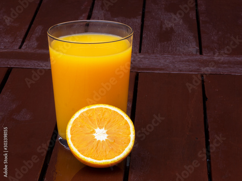 Glass of orange juice on wood