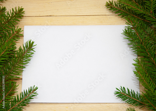 Christmas toys with fir branches on a wooden table, gift box, empty place, New Year concept. View from above.