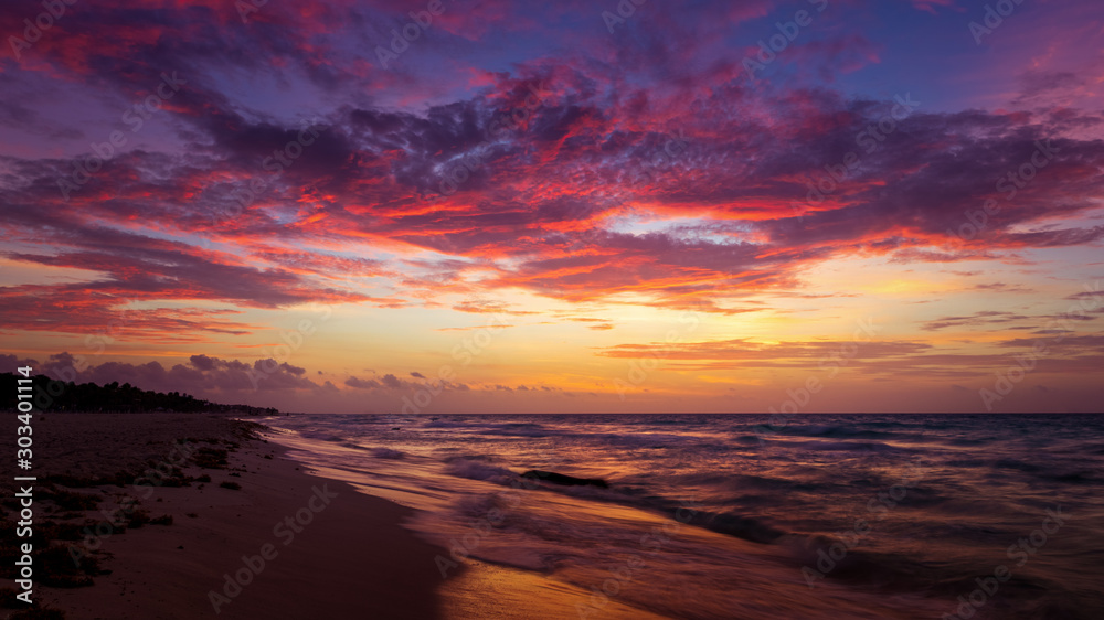 Dramatic cloudscape at sunrise at mexico caribbean beach - obrazy, fototapety, plakaty 