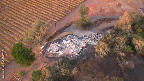 Aerial: Home burnt down from the california wildfires revealing its foundations. The hills and vineyards have been burnt from the Kincaid Wildfires that swept the region in October 2019.  photo