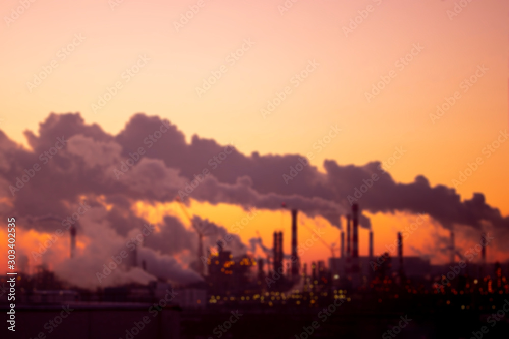 Defocus Violet smoke from the pipes at sunset, blurred industrial landscape. Environmental problems and air pollution