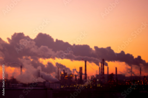 Defocus Violet smoke from the pipes at sunset  blurred industrial landscape. Environmental problems and air pollution