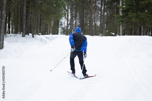Cross country. A skier is skiing in winter in the woods.
