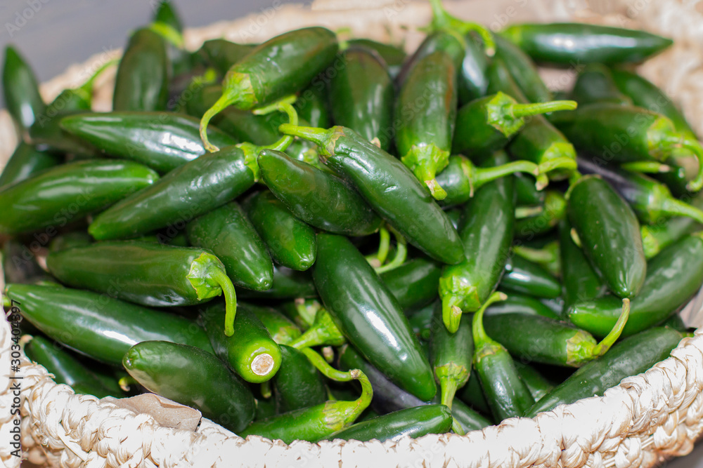 Green ripe jalapenos pepper in a wicker basket Green ripe jalapenos pepper in a wicker basket
