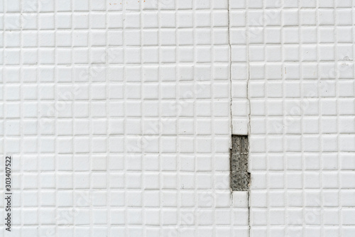 Old cracked white tile wall background