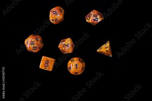 RPG set orange dice for playing role playing games on black blackground.