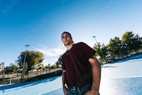 Young cool man break dancer standing in park. Tattoo on body photo