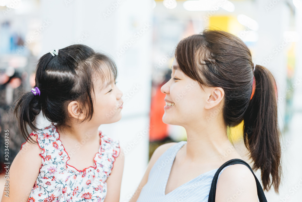 Laughing attractive asian mother and her cute little asian daughter in a supermarket.Mother and Daughter showing front teeth with big smile and laughing.Sale consumerism, Lifestyle, Dentistry Concept. Laughing attractive asian mother and her cute little asian daughter in a supermarket.Mother and Daughter showing front teeth with big smile and laughing.Sale consumerism, Lifestyle, Dentistry Concept.