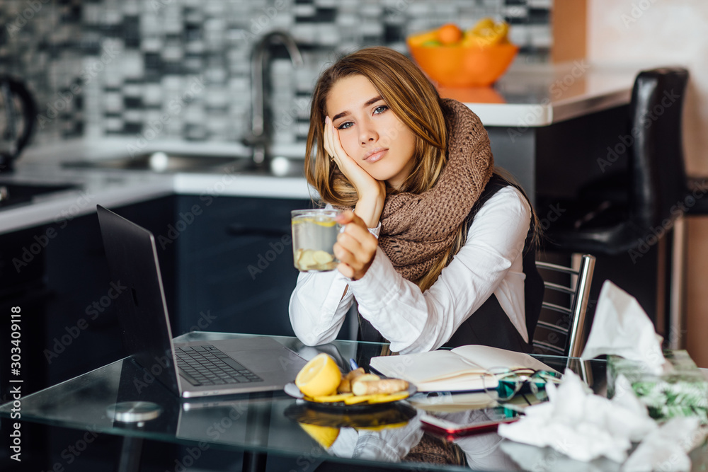 Φωτογραφία Young freelancer, business woman sitting at kitchen table and holding cup with hot drink, sick female illness
