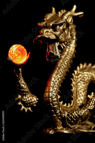 A small statue of a Chinese Dragon holding an orb