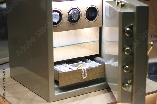 Security metal safe with pearl necklace, diamond jewelry and expensive watches inside