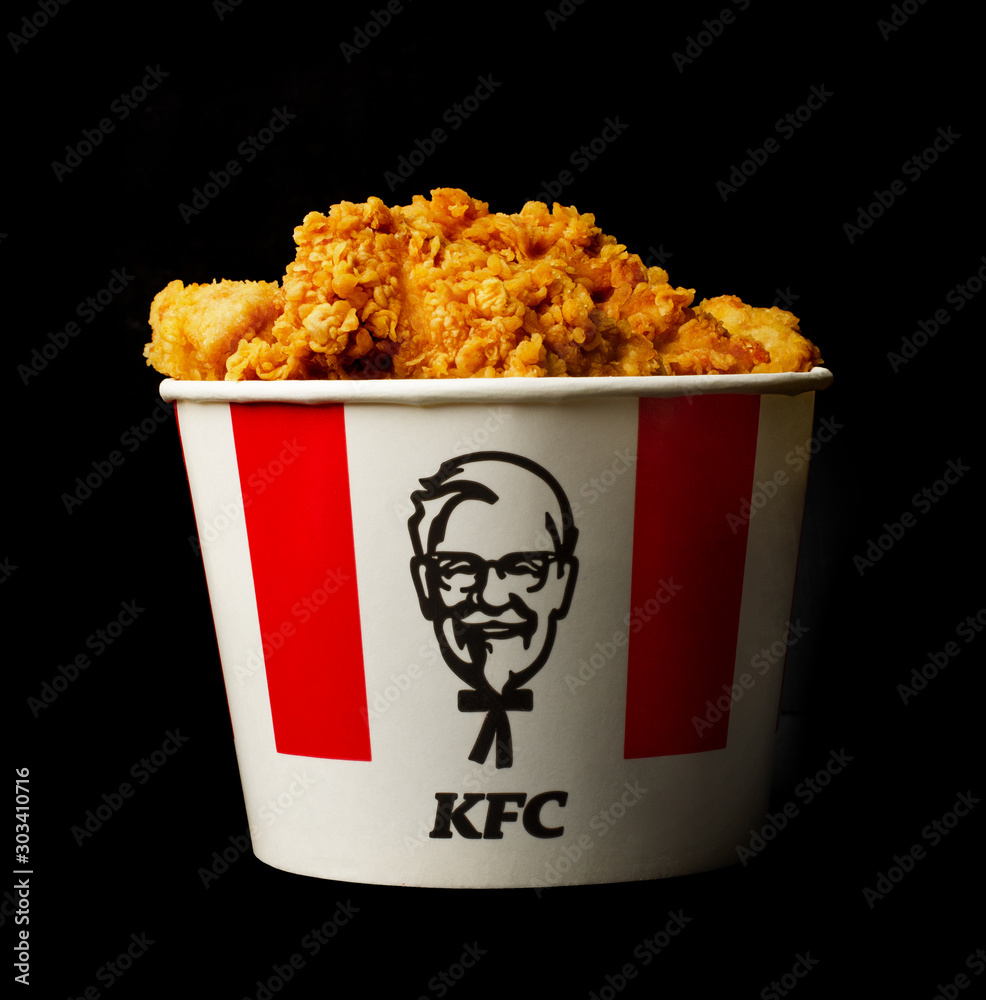 A lots of KFC chicken hot wings or strips in bucket of KFC (Kentucky Fried  Chicken) fast food. Photos | Adobe Stock