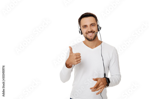 Call center worker man isolated on white background. Young smiling employee telesales agent using headset and showing Ok sign photo