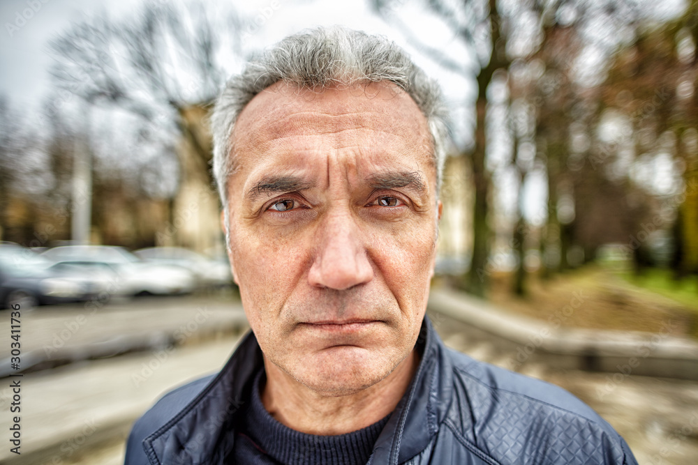 Middle-aged man with a serious look on the street. Middle-aged man with a serious look on the street.