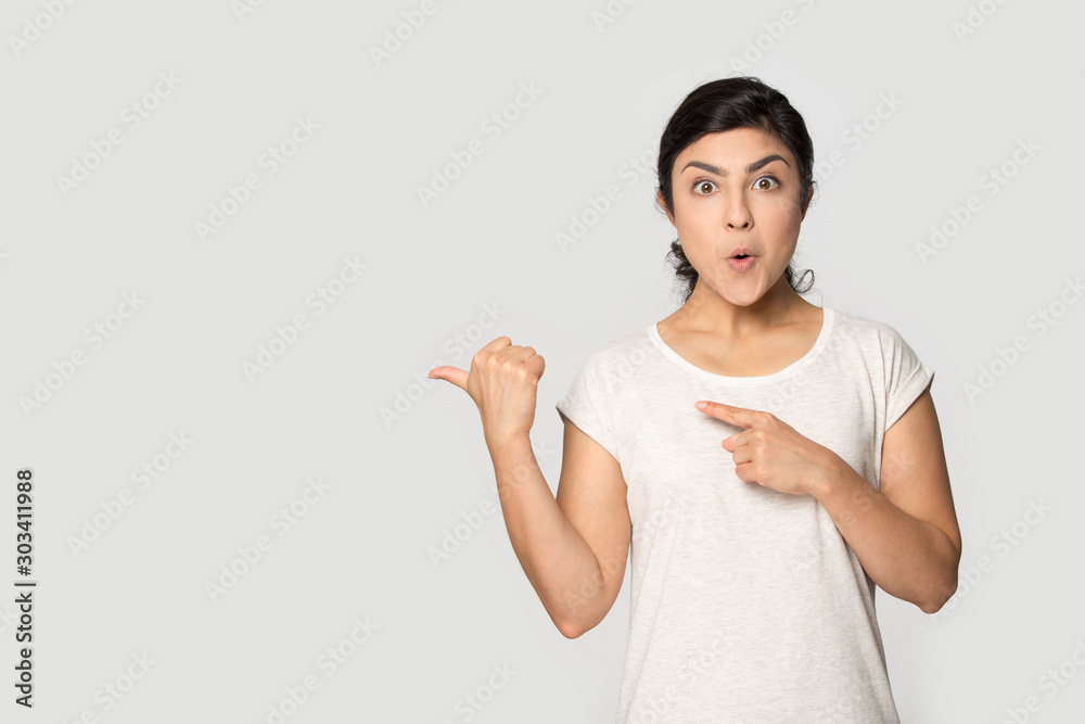 Surprised Indian girl pointing fingers to copy space, presenting product Surprised Indian girl pointing fingers to copy space, presenting product