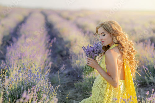 Woman with a bouquet in a field of young lavender on a spring day.