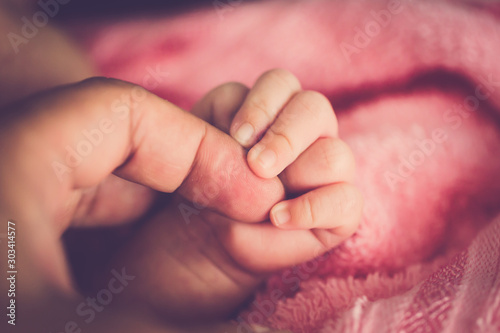 Baby hold her mom finger close up