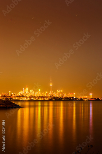 View of Toronto skyline and Lake Ontario from Humber Bay Park area during night time. 