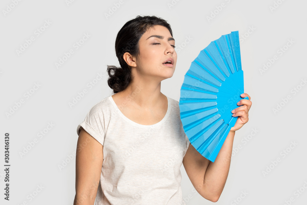 Tired exhausted Indian girl waving fan, suffering from heat Tired exhausted Indian girl waving fan, suffering from heat