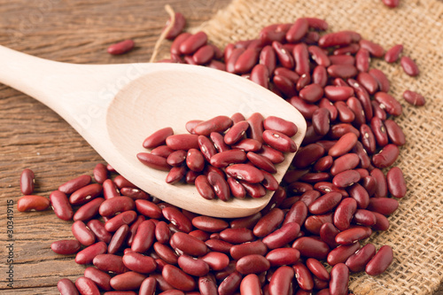 Red kidney bean close up rith spoon on wooden desk photo