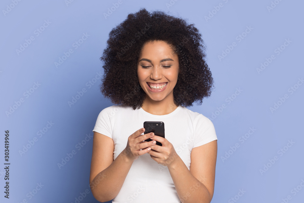 Happy smiling African American girl using phone, looking at screen Happy smiling African American girl using phone, looking at screen