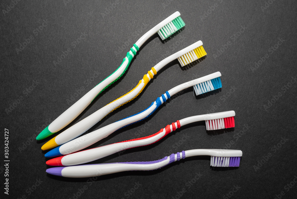 multi-colored toothbrushes on black background multi-colored toothbrushes on black background