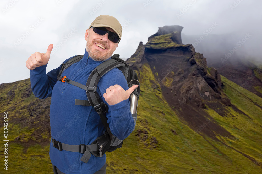 happy tourist man on the background of the mountain. Beautiful mountain landscape in Iceland