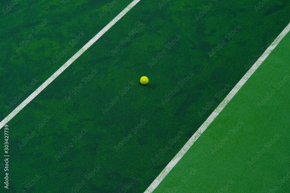 Tennis ball near the line on tennis grass court from top view.