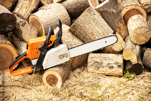 Chainsaw in action cutting wood. Man cutting wood with saw, dust and movements. Chainsaw. Close-up of woodcutter sawing chain saw in motion, sawdust fly to sides.