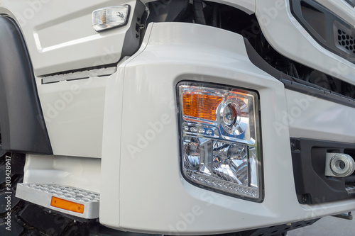 White truck cab. Fragment. Headlight and bumper, footrest and door. Front side view. © Николай Глухов